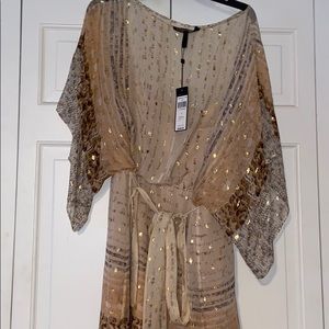Beige dress adorned with gold accents